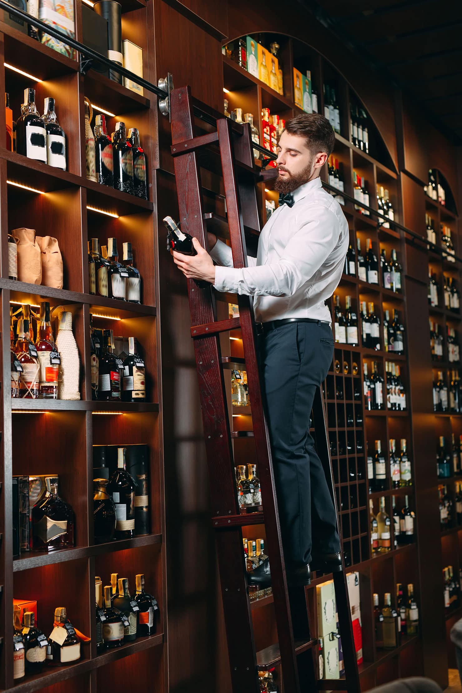 Sommelier presenting a wine bottle to diners, highlighting staff engagement.